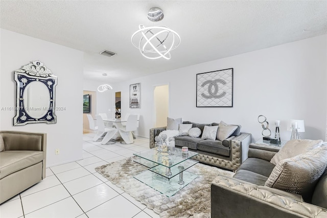 living room with a textured ceiling, light tile patterned floors, and an inviting chandelier