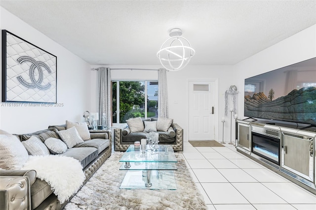 living room with a notable chandelier, light tile patterned flooring, and a textured ceiling