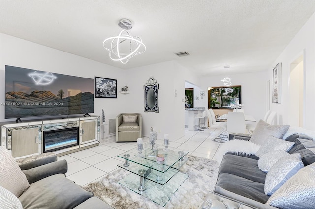 tiled living room featuring a chandelier and a textured ceiling