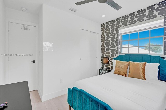 bedroom with a closet, ceiling fan, and light hardwood / wood-style floors