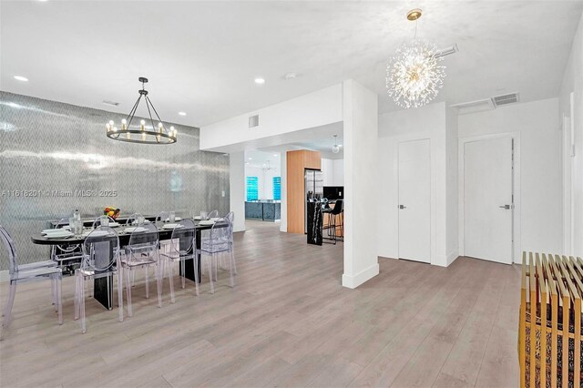 dining room featuring an inviting chandelier and light hardwood / wood-style flooring