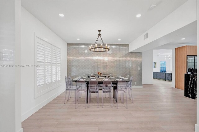 dining room featuring light hardwood / wood-style floors and a chandelier