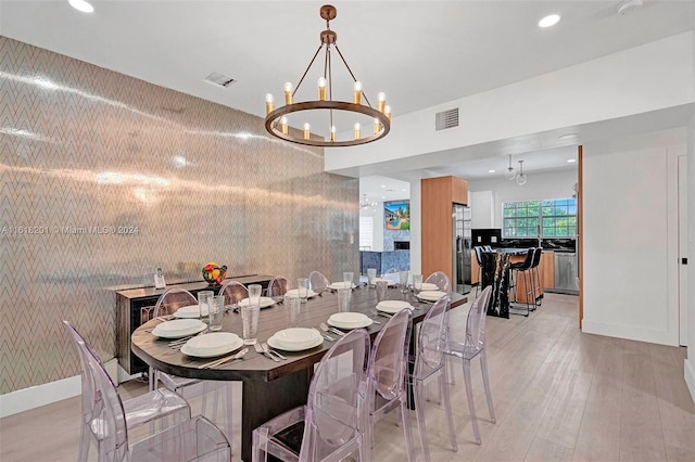 dining area with a chandelier and light hardwood / wood-style floors