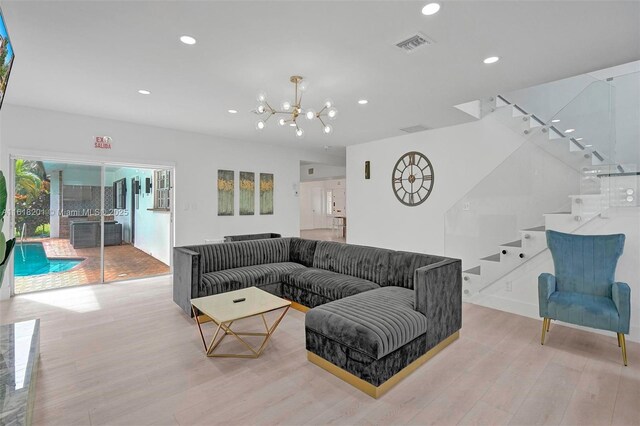 living room with a chandelier and light hardwood / wood-style flooring