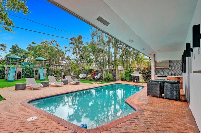 view of pool featuring a patio and a playground