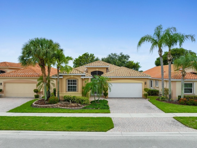 mediterranean / spanish-style house featuring a front yard and a garage