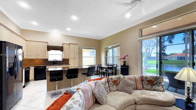 tiled living room with ceiling fan, sink, and ornamental molding