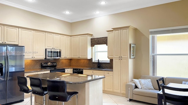 kitchen featuring black appliances, a kitchen island, light tile patterned floors, and sink