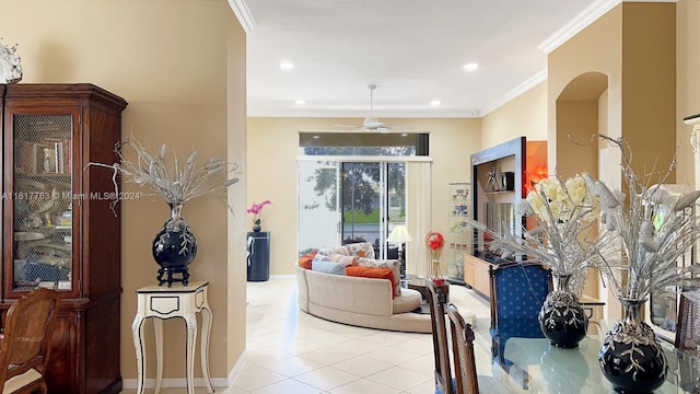 tiled living room with ceiling fan and ornamental molding