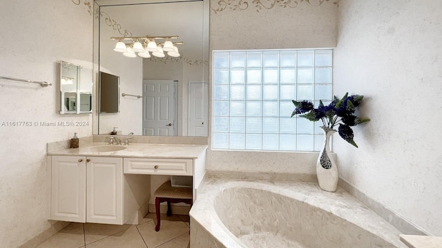 bathroom featuring tile patterned flooring, vanity, and a relaxing tiled tub