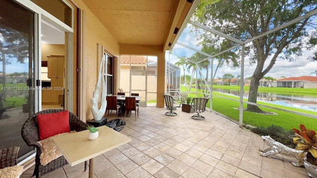 sunroom featuring a water view