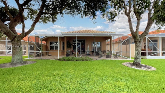 back of house featuring a lanai, a patio area, and a yard