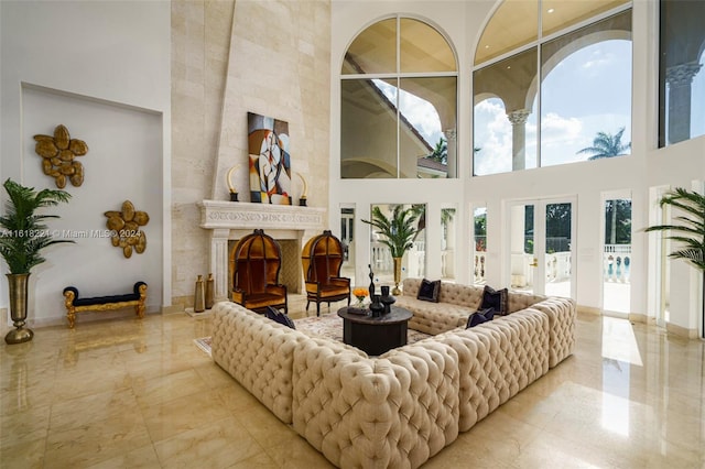 living room featuring a high end fireplace, a high ceiling, and light tile patterned floors