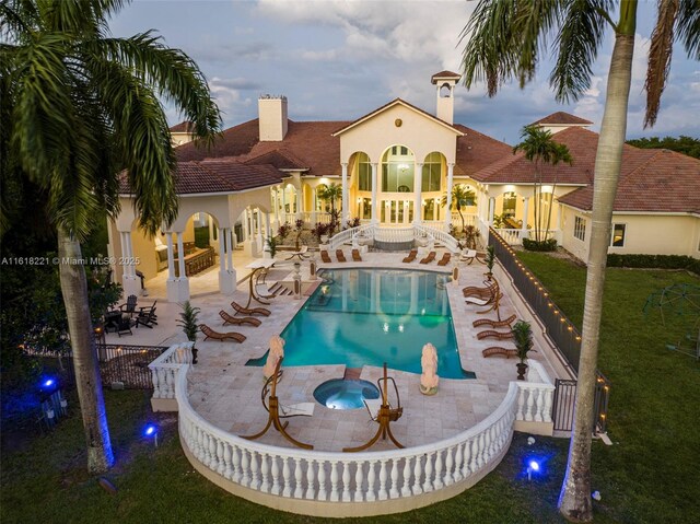 view of swimming pool featuring a patio, a hot tub, and a lawn