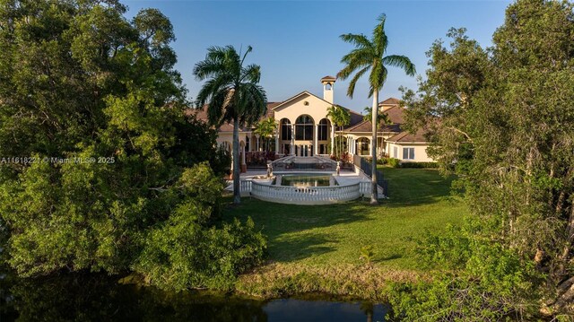 back of house featuring a water view and a yard