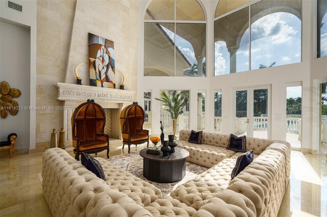 tiled living room with a high ceiling and french doors