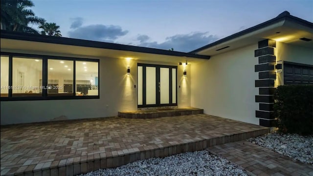 exterior entry at dusk with a patio area