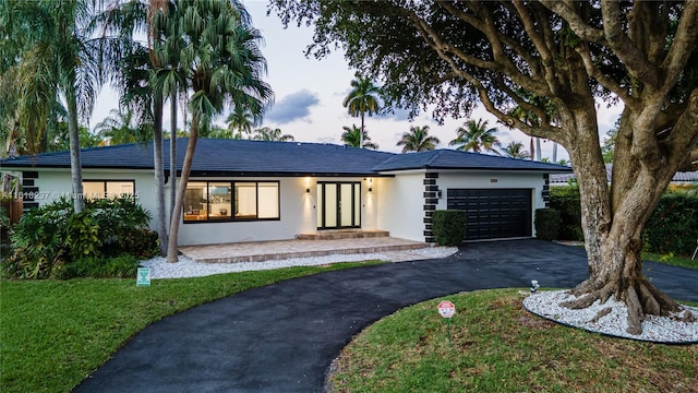 ranch-style home with a garage and a front yard