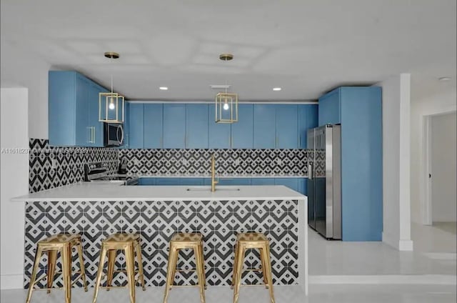 kitchen with pendant lighting, blue cabinets, stainless steel appliances, and kitchen peninsula