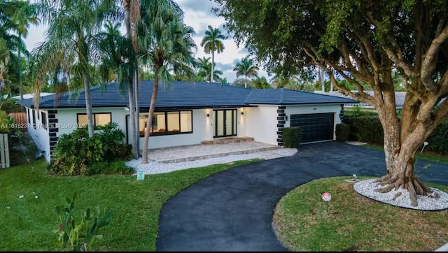 single story home with a garage and a front lawn