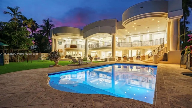 pool at dusk with a patio area