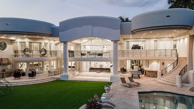 back house at dusk featuring a patio