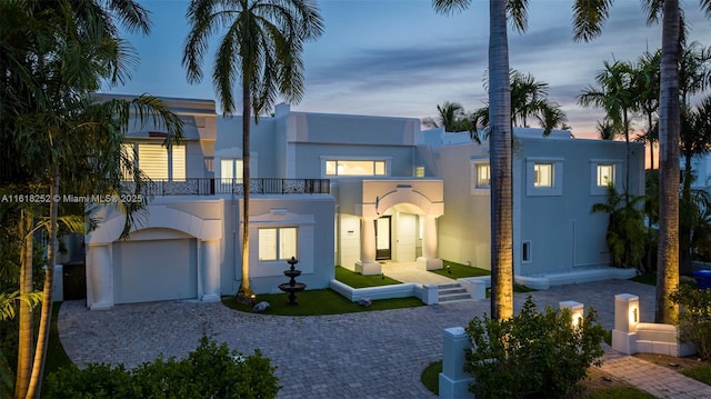 view of front facade featuring a garage and a balcony