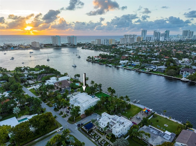 aerial view at dusk featuring a water view