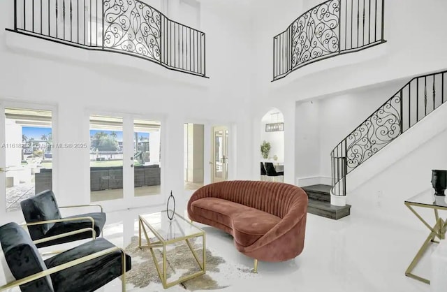 living room with concrete floors, french doors, and a high ceiling