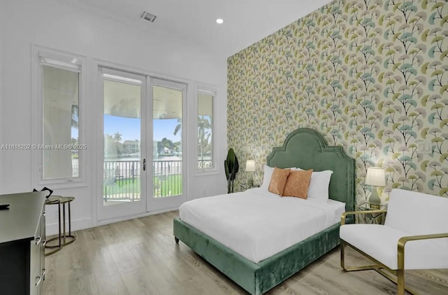 bedroom with access to exterior, light hardwood / wood-style flooring, and french doors