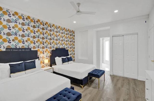 bedroom with light hardwood / wood-style floors, a closet, and ceiling fan