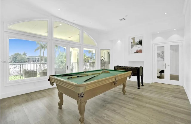 recreation room featuring pool table, light hardwood / wood-style floors, and french doors