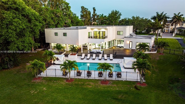 back of property with a community pool, a yard, a patio area, and a balcony