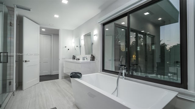 bathroom with vanity and separate shower and tub