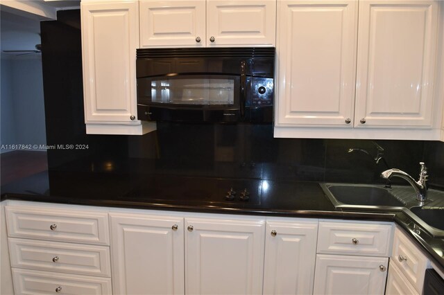 kitchen with white cabinets, sink, and backsplash