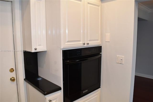 kitchen featuring white cabinets and black oven