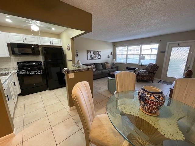 dining room with ceiling fan, light tile patterned floors, and a textured ceiling