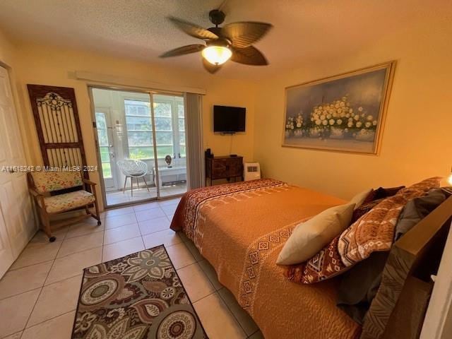 tiled bedroom with ceiling fan, a textured ceiling, and access to outside