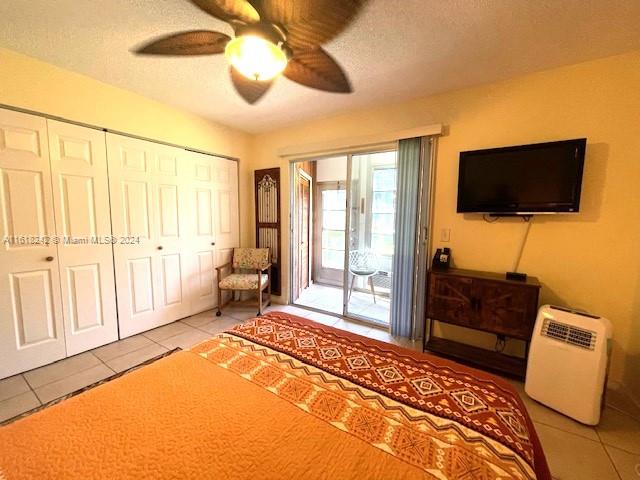 bedroom with light tile patterned floors, a textured ceiling, access to outside, and ceiling fan