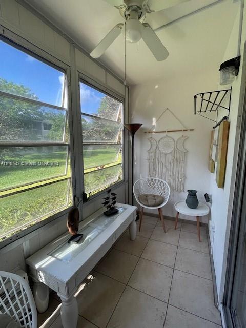 unfurnished sunroom with ceiling fan