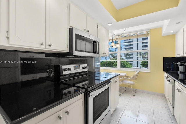 kitchen featuring white cabinetry, stainless steel appliances, backsplash, and light tile patterned floors