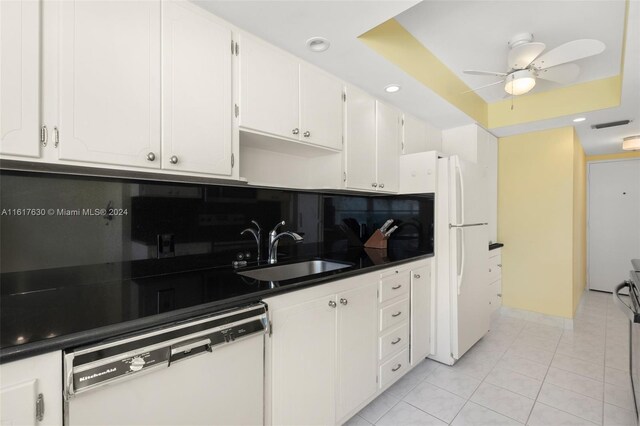 kitchen with white appliances, sink, backsplash, white cabinetry, and ceiling fan