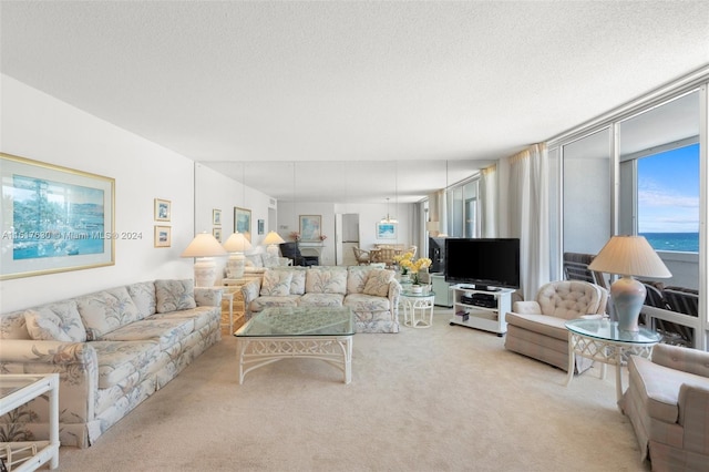 living room with a water view, carpet, and a textured ceiling