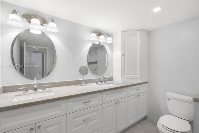 bathroom featuring double vanity, tile patterned floors, and toilet