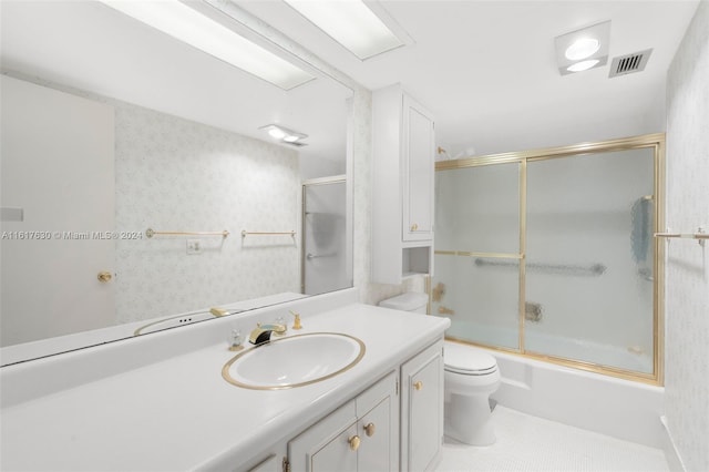 full bathroom featuring combined bath / shower with glass door, tile patterned floors, toilet, and vanity