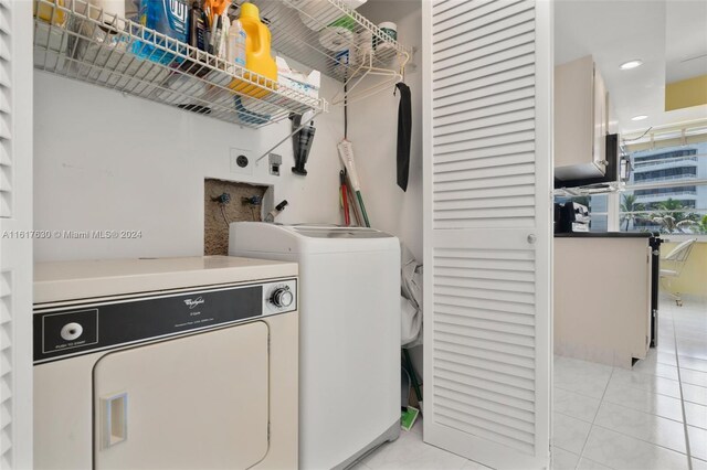 clothes washing area featuring light tile patterned flooring and independent washer and dryer