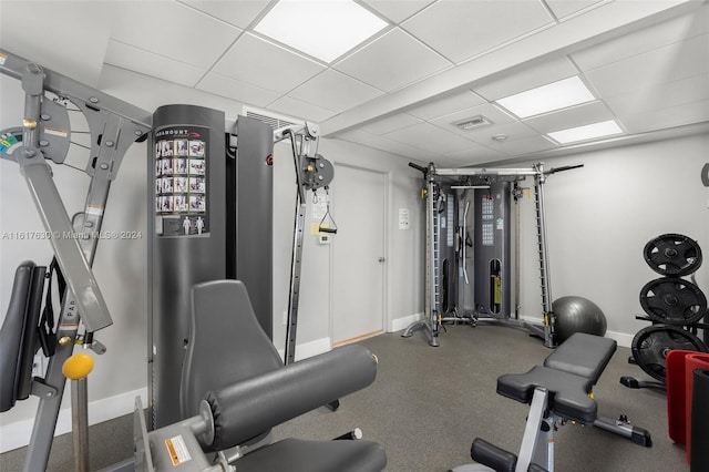 exercise room with a drop ceiling and carpet flooring