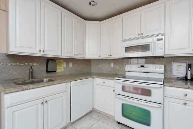 kitchen featuring white cabinetry, white appliances, light tile patterned floors, light stone countertops, and sink