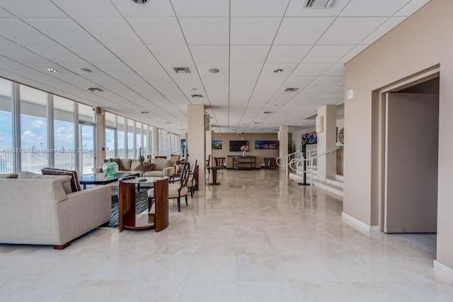 tiled living room featuring a wall of windows