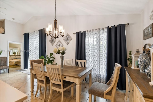 dining area with a notable chandelier, lofted ceiling, light tile patterned floors, and a healthy amount of sunlight